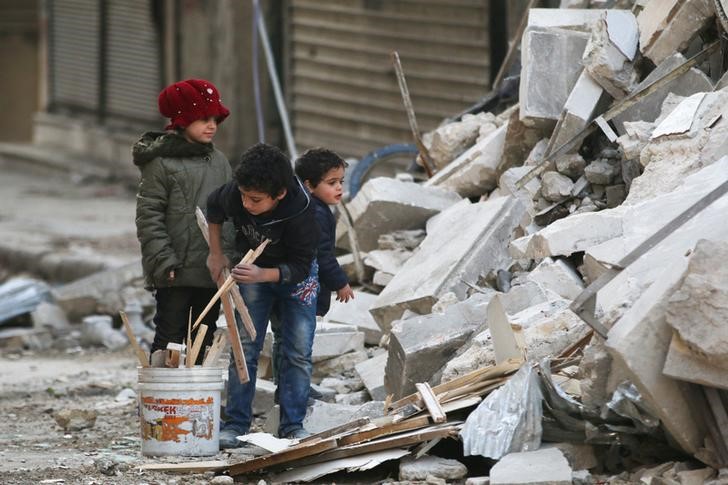 © Reuters. Crianças recolhem destroços após ataques aéreos em bairro de Aleppo