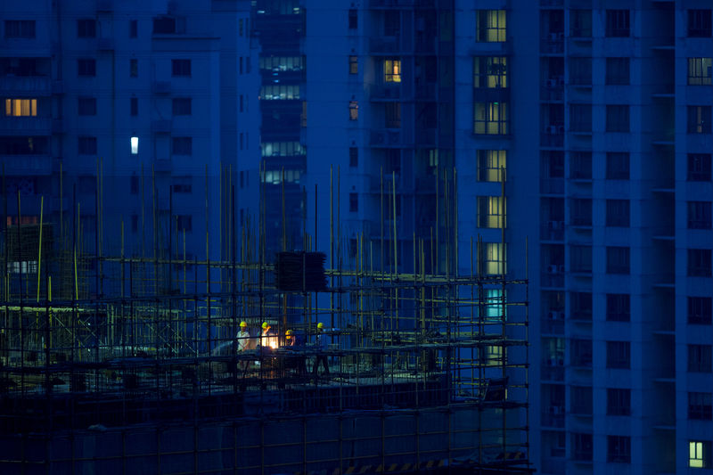 © Reuters. Labourers work atop scaffolding at a residential construction site in Shanghai