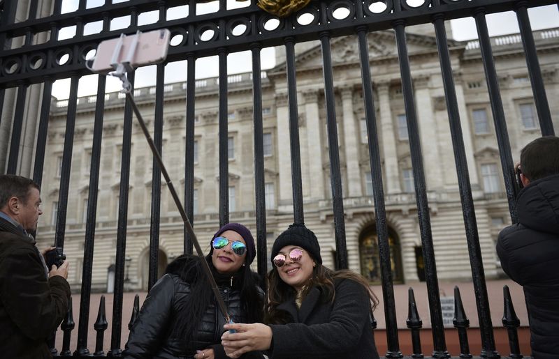 © Reuters. People take a selfie in front of Buckingham Palace in central London