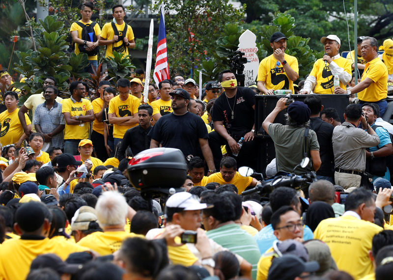 © Reuters. Members of pro-democracy group Bersih listen to former Malaysian prime minister Mahathir Mohammad at a rally during a 1MDB protest, calling for Prime Minister Najib Abdul Razak to resign, in Kuala Lumpur, Malaysia