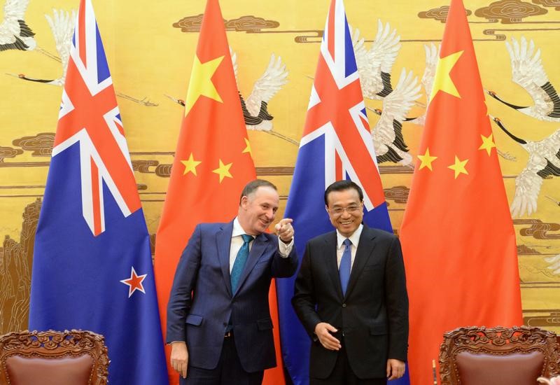 © Reuters. New Zealand's Prime Minister John Key gestures as he shares a laugh with China's Premier Li Keqiang during a signing ceremony at the Great Hall of the People in Beijing