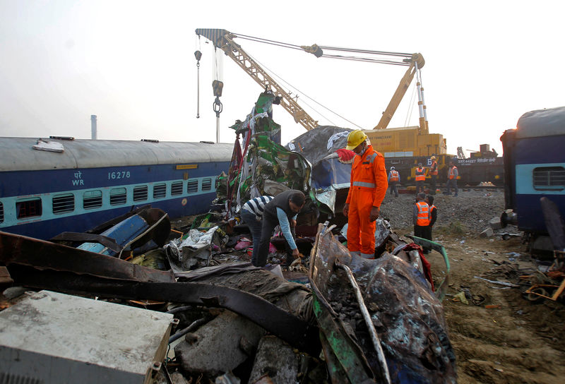 © Reuters. Rescue workers search for survivors at the site of Sunday's train derailment in Pukhrayan, south of Kanpur city