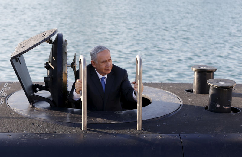 © Reuters. File photo of Israeli Prime Minister Benjamin Netanyahu climbing out after a visit inside the Rahav, the fifth submarine in the fleet, after arriving in the Haifa port