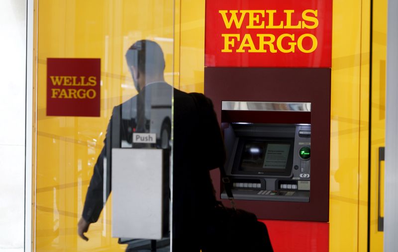 © Reuters. A man walks by a bank machine at the Wells Fargo & Co. bank in downtown Denver