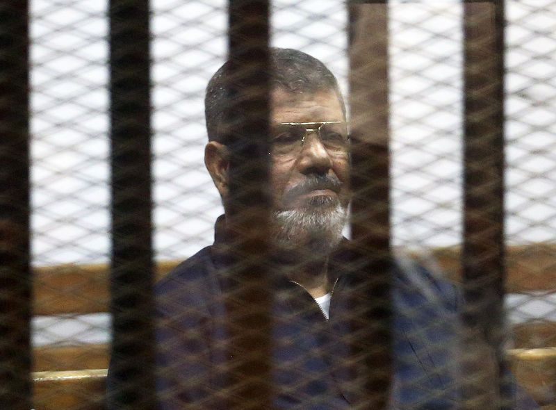 © Reuters. File photo of deposed Egyptian President Mursi listening to his verdict behind bars at a court on the outskirts of Cairo