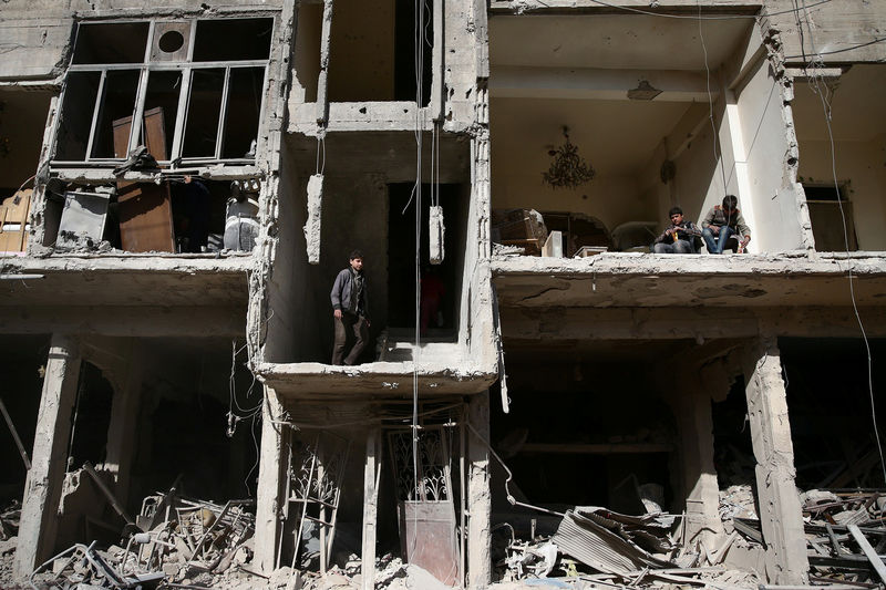 © Reuters. People inspect a damaged building after strikes yesterday on the rebel held besieged city of Douma, in the eastern Damascus suburb of Ghouta