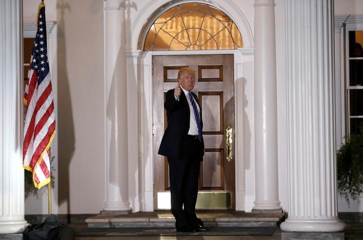 © Reuters. U.S. President-elect Donald Trump gestures to members of the news media from the front steps at the main clubhouse at Trump National Golf Club in Bedminster