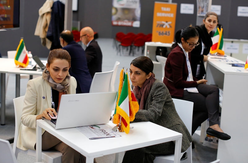 © Reuters. Iranian exhibitors sit in a pavilion during the opening of the fair "Iran country presentation" in Rome