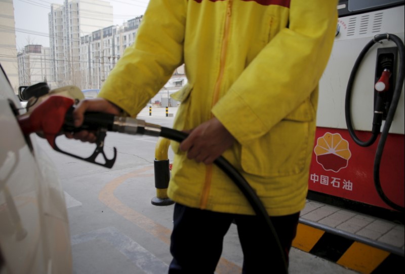 © Reuters. A gas station attendant puts fuel into a customer's car at PetroChina's filling station in Beijing