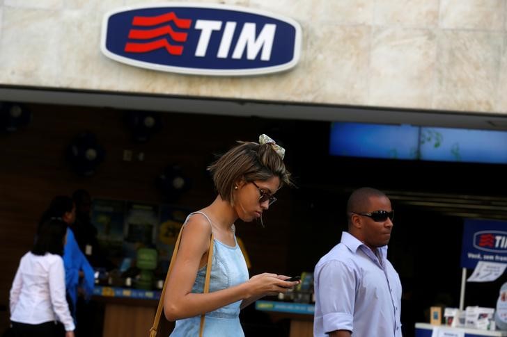 © Reuters. People walk in front of a Telecom Italia Mobile (TIM) store in downtown Rio de Janeiro