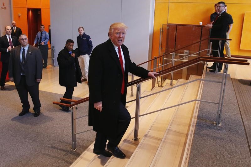 © Reuters. U.S. President elect Donald Trump walks up a staircase to depart the lobby of the New York Times building after a meeting in New York