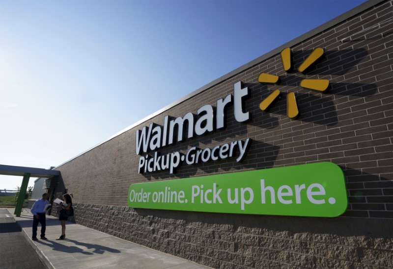 © Reuters. People talk outside a Wal-Mart Pickup-Grocery test store in Bentonville