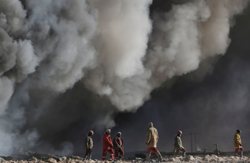 © Reuters. عمال النفط العراقيون يواجهون النيران والألغام لإغلاق أبار مشتعلة