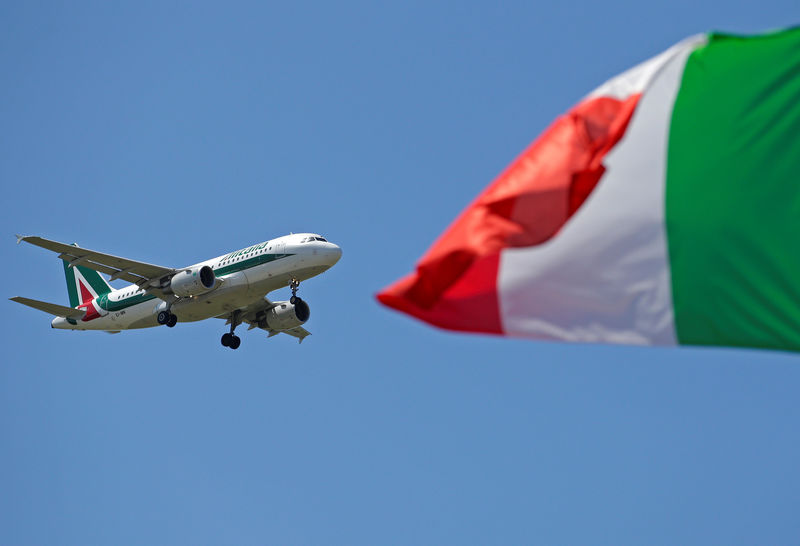 © Reuters. An Italy flag flutters as an Alitalia airplane approaches to land at Fiumicino airport in Rome