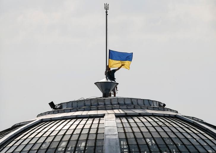 © Reuters. A climber installs the Ukrainian national flag on a roof, marking the Day of the State Flag in Kiev