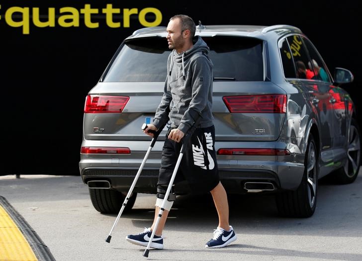 © Reuters. Barcelona's injured soccer player Iniesta takes part in a commercial event near Camp Nou stadium in Barcelona