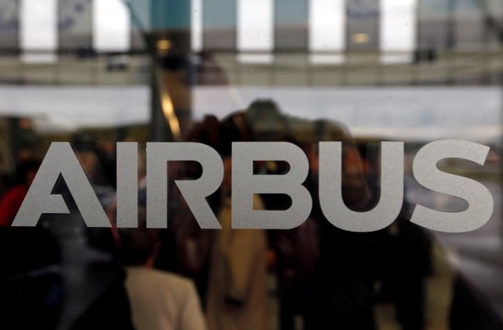 © Reuters. People are seen in silhouette behind the logo of Airbus during the Airbus A350-1000 maiden flight event in Colomiers near Toulouse