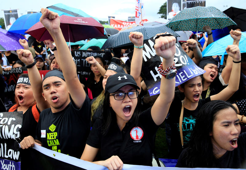 © Reuters. Protesters clench their fists during a protest at a Luneta park, metro Manila