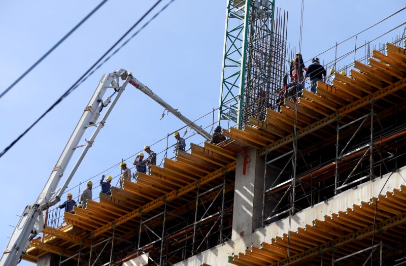 © Reuters. Workers work at a construction site to build an office building and shopping mall in a residential area in Buenos Aires