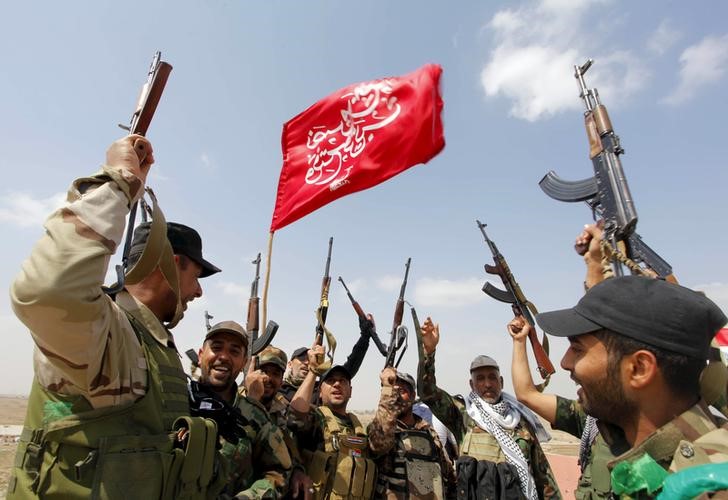 © Reuters. Members of the Hashid Shaabi forces, which allied with Iraqi forces, chant slogans against the Islamic State in Tikrit