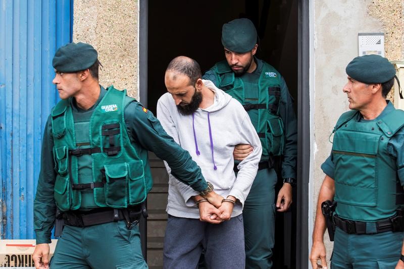 © Reuters. Spanish civil guards lead a man detained on suspicion of belonging to Islamic State after searching his home in Vecindario, in the Canary Island of Gran Canaria