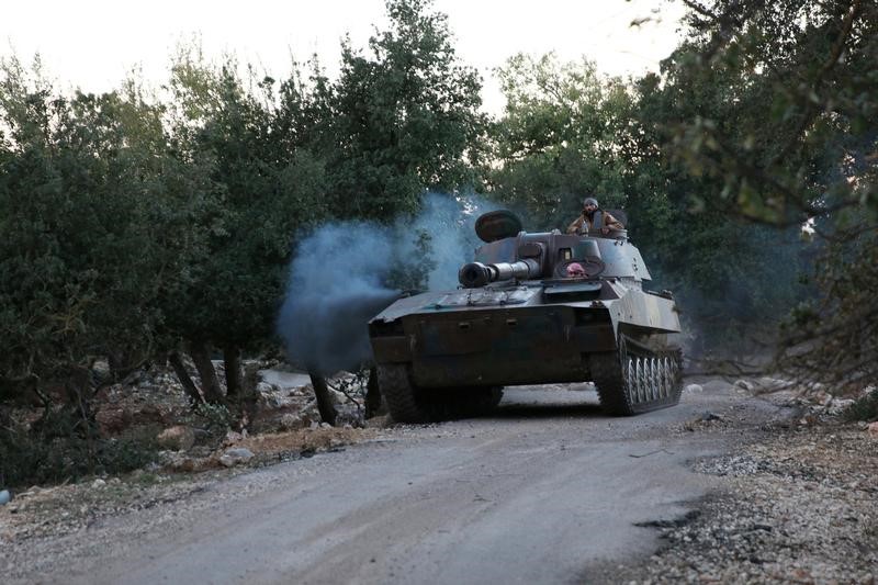 © Reuters. مقاتلو المعارضة السورية يسلمون أسلحتهم الثقيلة في بلدة محاصرة بريف دمشق