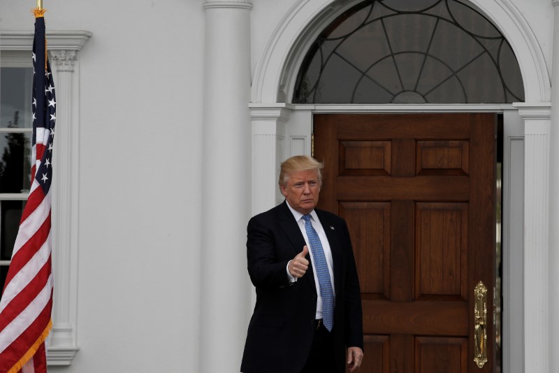 © Reuters. U.S. President-elect Donald Trump gestures from the front door at the main clubhouse at Trump National Golf Club in Bedminster