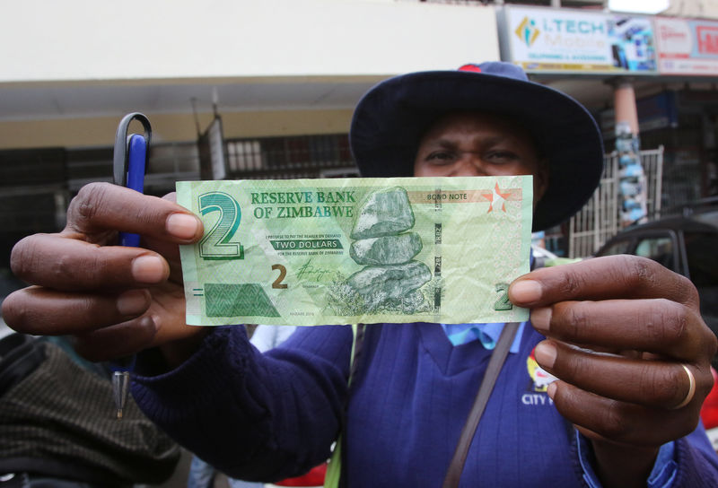 © Reuters. A Zimbabwean woman shows off a new bond note outside a bank in the capital Harare,Zimbabwe