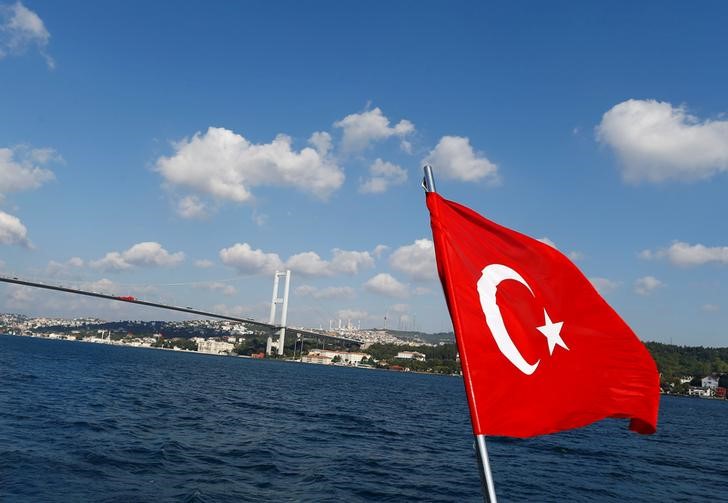 © Reuters. A Turkish flag is pictured on a boat with the Bosphorus bridge in the background in Istanbul