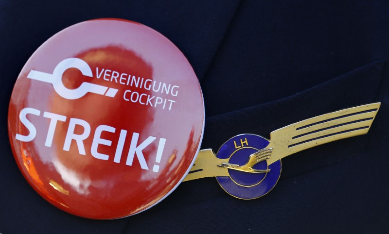 © Reuters. Lufthansa pilot wears badge reading "strike" on his uniform as he takes part in a demonstration at Fraport airport in Frankfurt