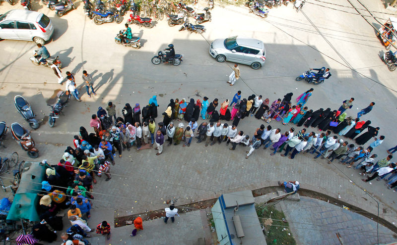 © Reuters. People queue to deposit or exchange their old high denomination banknotes outside a bank in Allahabad