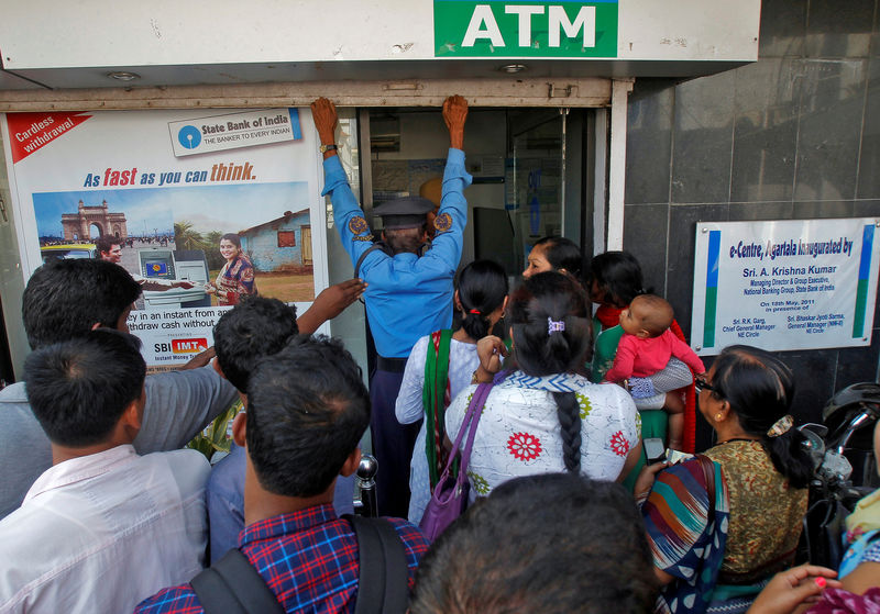 © Reuters. A security guard closes the shutter of State Bank of India ATM after it stopped dispensing cash in Agartala