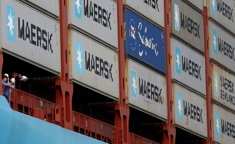 © Reuters. Crew members look out from the MV Maersk Mc-Kinney Moller as it berths at a PSA International port terminal in Singapore
