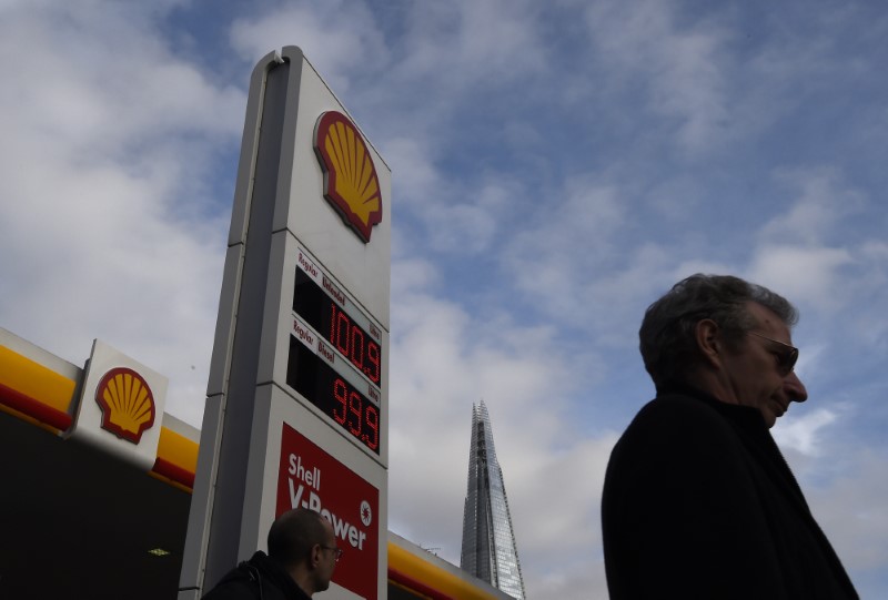 © Reuters. The UK £ sterling price per litre of different blends of refined petrol (US $ 1.43 per litre unleaded) is seen at a Shell fuel station, with the Shard skyscraper seen behind, in central London, Britain