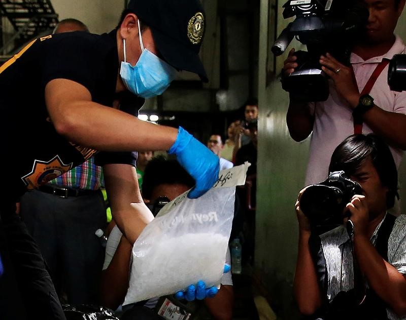 © Reuters. A police investigator inspects a plastic bag of Methamphetamine, locally named Shabu, worth 120 million pesos ($2.41 million), that were confiscated during a drug-buy bust police operation in Manila