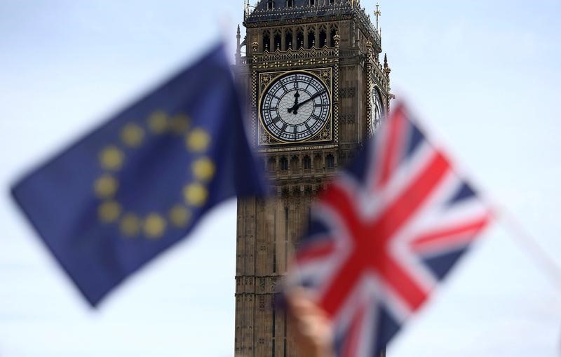 © Reuters. Participants hold a British Union flag and an EU flag during a pro-EU referendum event at Parliament Square in London