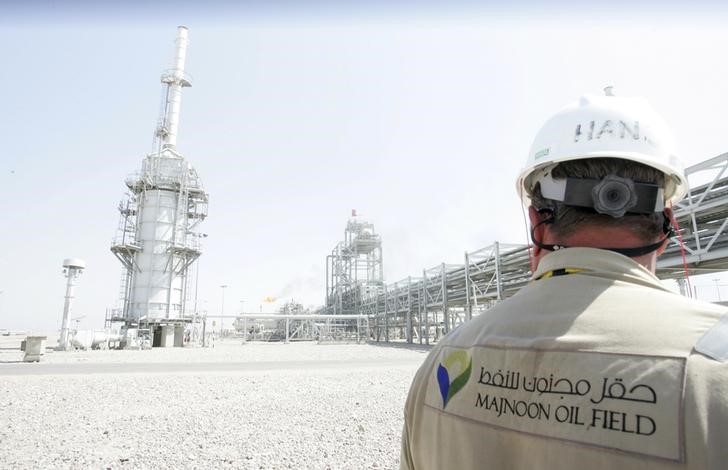 © Reuters. Рабочий на нефтяном месторождении Меджнун недалеко от Басры