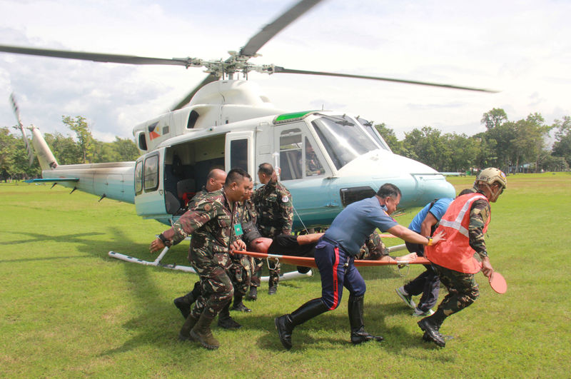 © Reuters. Soldiers carry on a stretcher a wounded member of Philippine President Duterte's presidential security group who was airlifted at an army camp in Cagayan de Oro