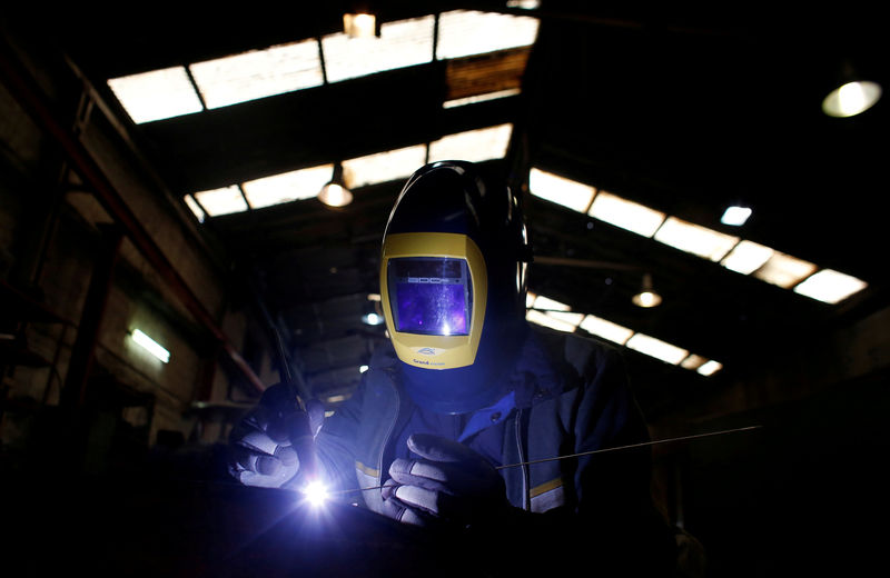 © Reuters. Mitsos Dan, a worker from Albania, welds parts of agricultural machinery at a factory in Athens