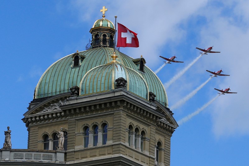 © Reuters. Four Pilatus PC-7 aircrafts of the Swiss Air Force fly over the Swiss Parliament building in Bern