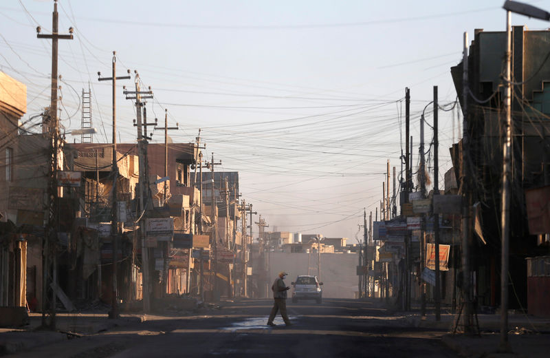 © Reuters. A man walks across a street in Qaraqosh, east of Mosul, Iraq