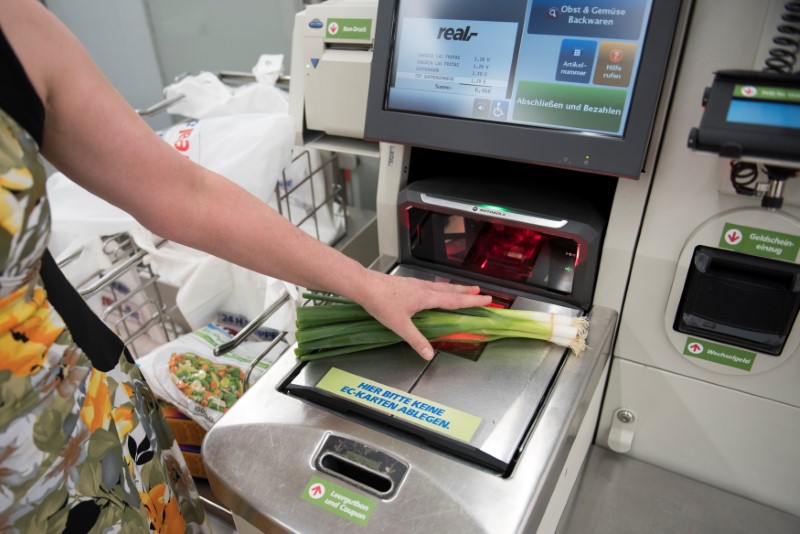 © Reuters. Customer weighs vegetable at self service point of sale terminal in store in Berlin