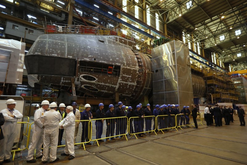 © Reuters. Workers stand in front of HMS Anson, under construction, at BAE Systems in Barrow-In-Furness