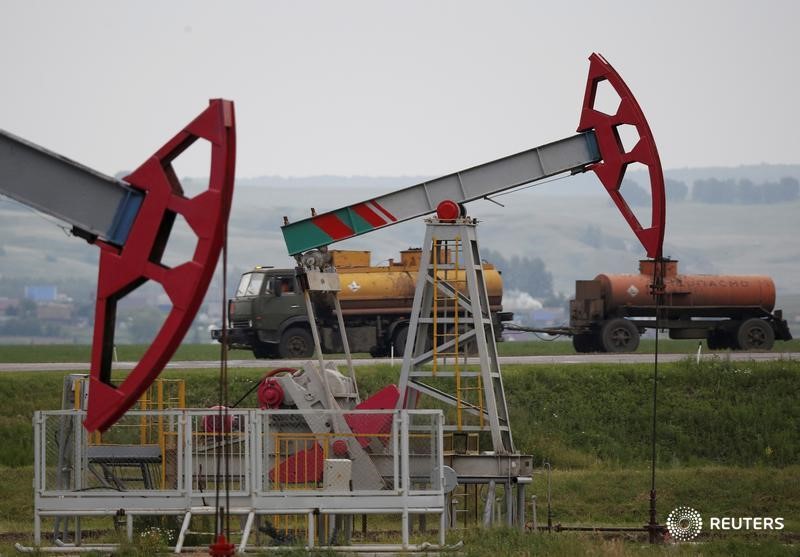 © Reuters. Truck drives past pump jacks at oil field Buzovyazovskoye owned by Bashneft company north from Ufa