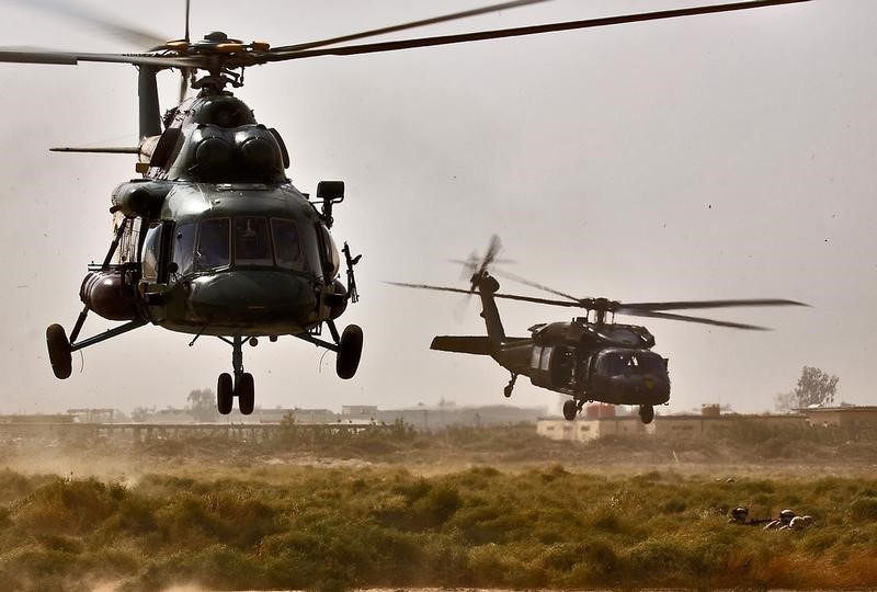 © Reuters. An MI-17 Hip helicopter from the Iraqi Air Force and a UH-60 Black Hawk helicopter from 3rd Battalion, 227th Aviation Regiment, 1st Air Cavalry Brigade, 1st Cavalry Division, drop off soldiers