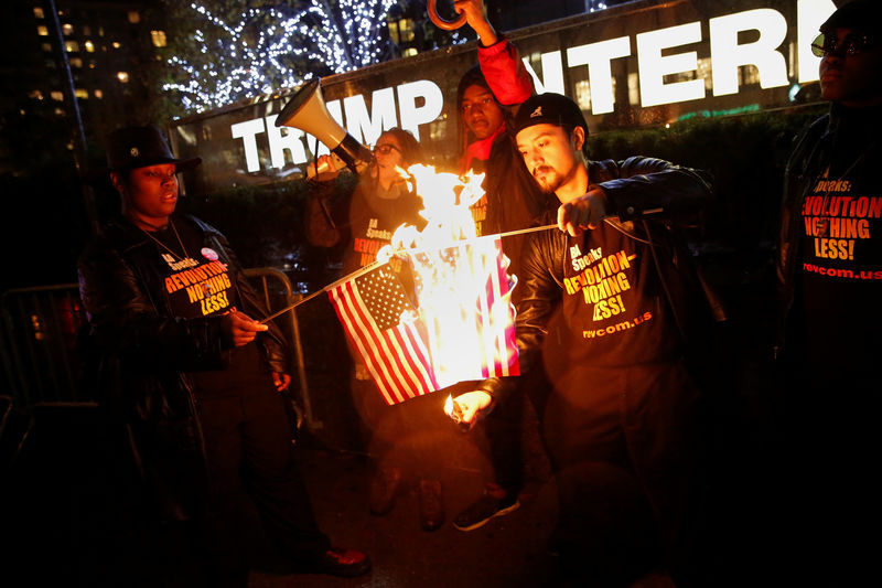 © Reuters. Supporters of the "NYC Revolution Club" burn the U.S. flag outside the Trump International Hotel and Tower in New York