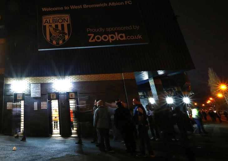 © Reuters. West Bromwich Albion fans gather below a Zoopla sign before their English Premier League soccer match against Everton at the Hawthorns in West Bromwich