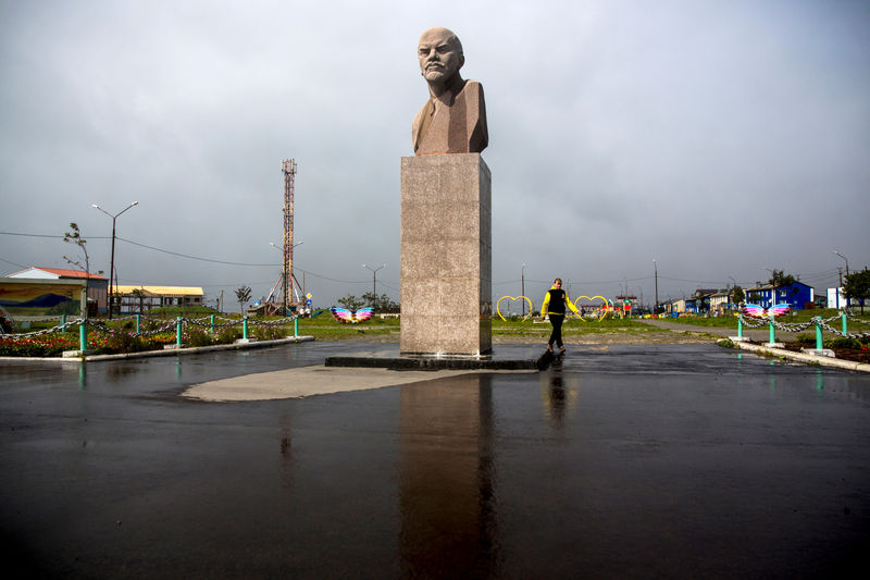 © Reuters. Woman walks past a statue of Soviet state founder Vladimir Lenin in Yuzhno-Kurilsk, the main settlement on the Southern Kuril island of Kunashir