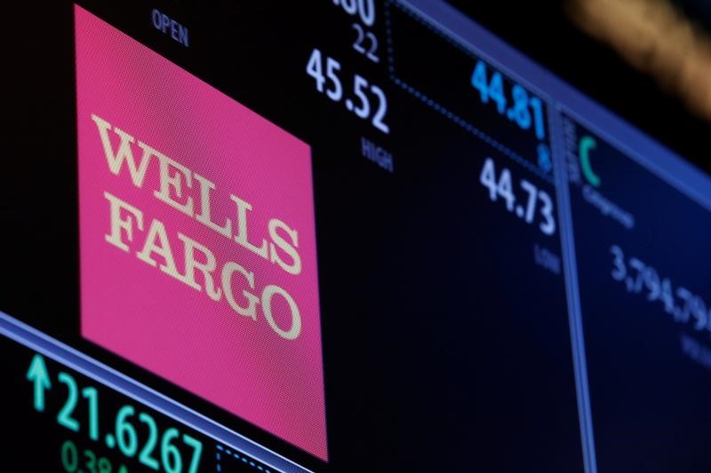 © Reuters. The logo and trading information for Wells Fargo are displayed on a screen on the floor of the NYSE
