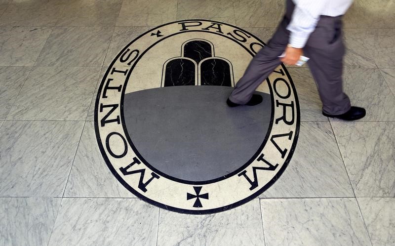 © Reuters. A man walks on a logo of the Monte Dei Paschi Di Siena bank in Rome